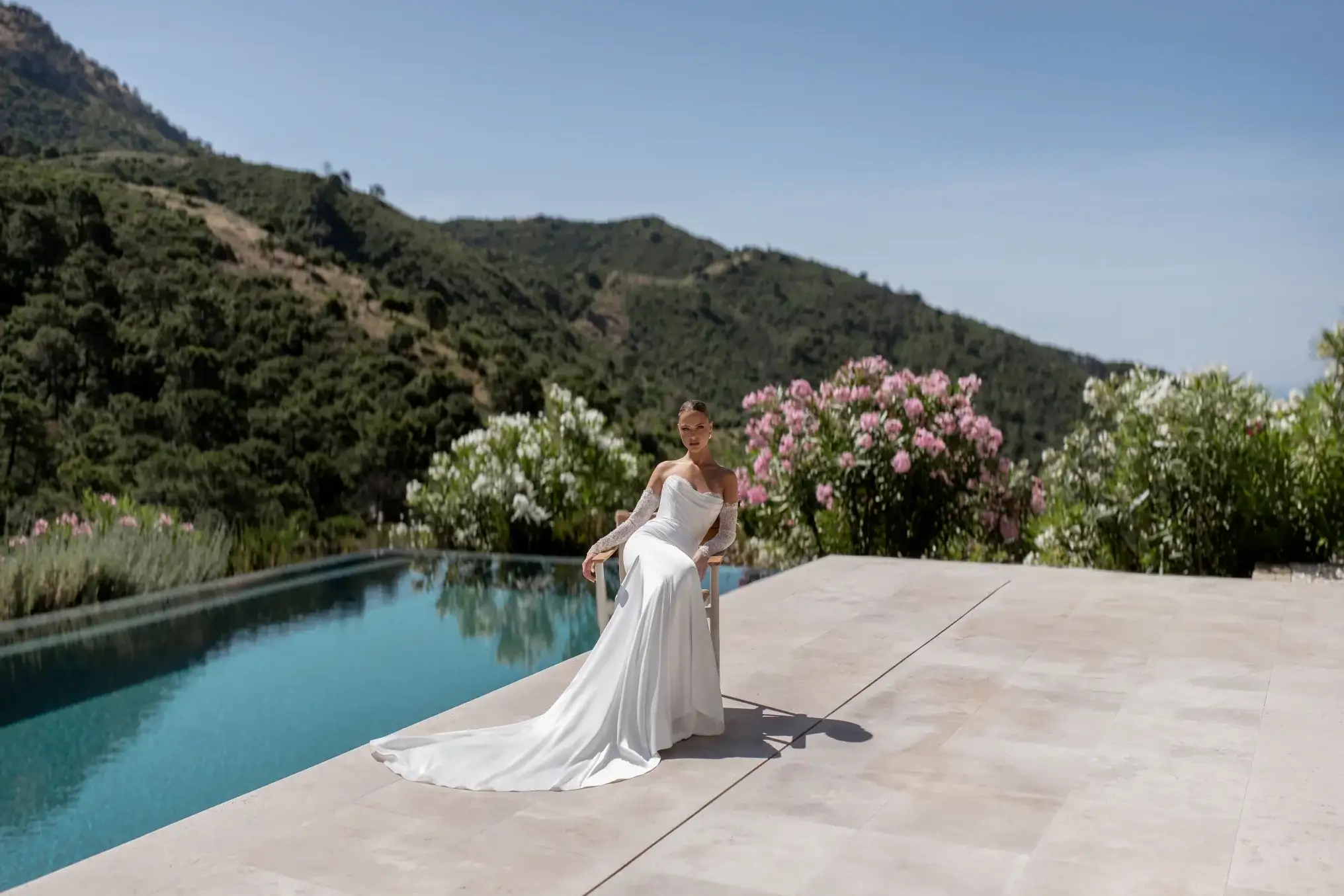 Model wearing the Sofia Cruz Roda sheath dress beside a pool.