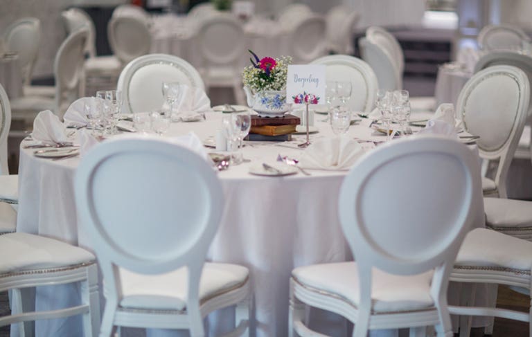 White table and chairs laid out ready for guests with vintage table decorations