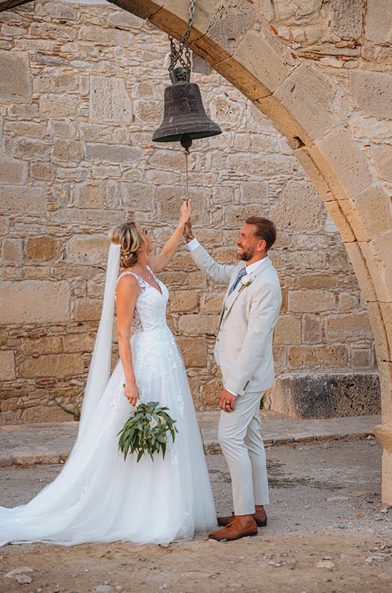 Katie and James ringing the bell at their wedding venue