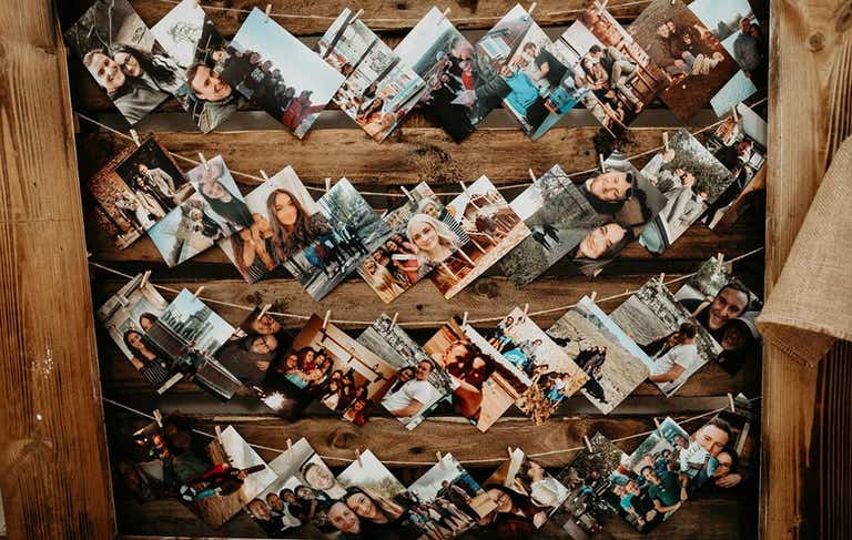 Photos of the bride and groom over the years strung on a board