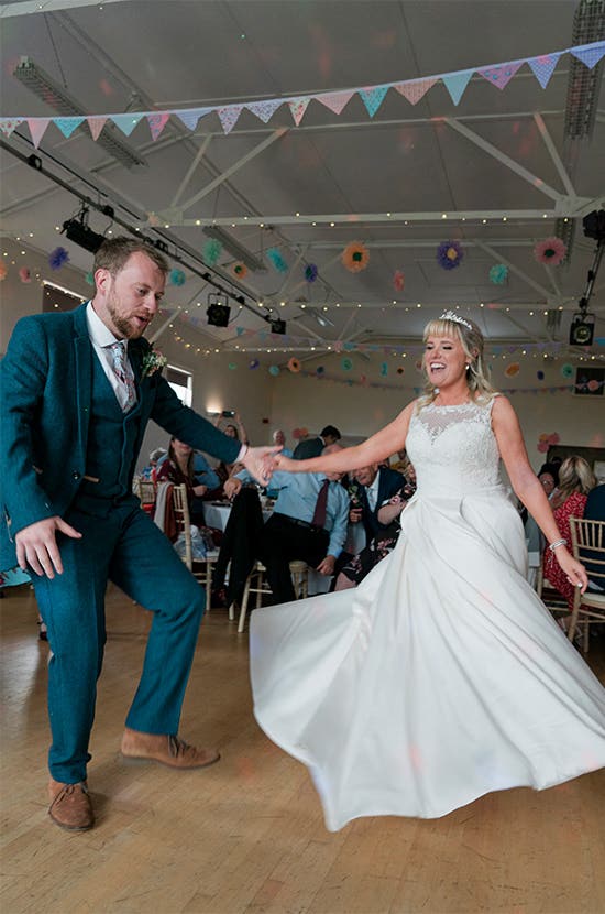 Bride and Groom smiling while dancing at their wedding
