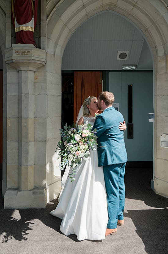 Bride and Groom kissing outside the Church