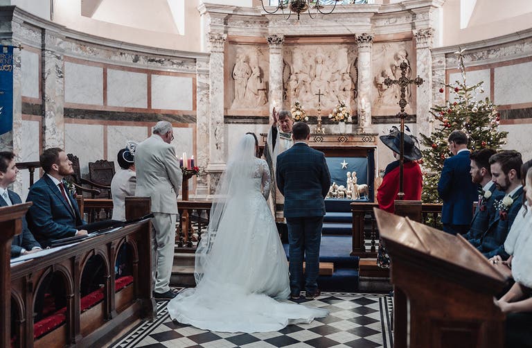 Rhiannon and Edward standing at the front of the Church during their ceremony