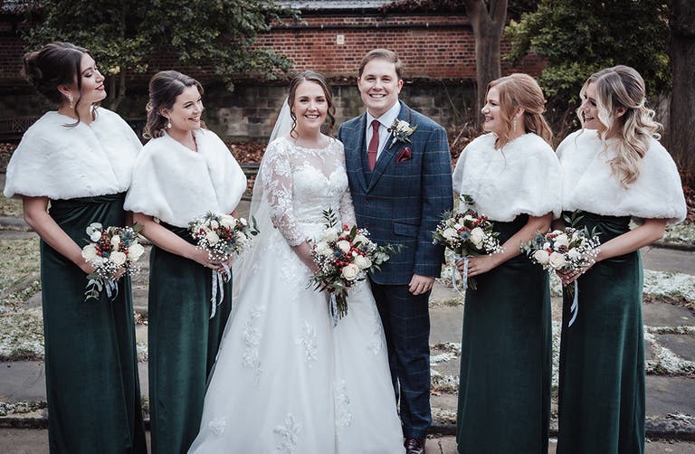 Rhiannon and Edward posing with their bridesmaids outside