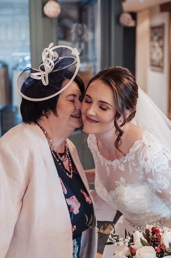 Rhiannon being kissed on the cheek on her wedding day