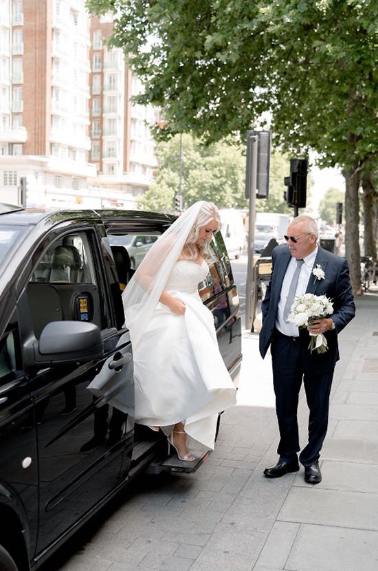 Bride and groom walking towards manor house