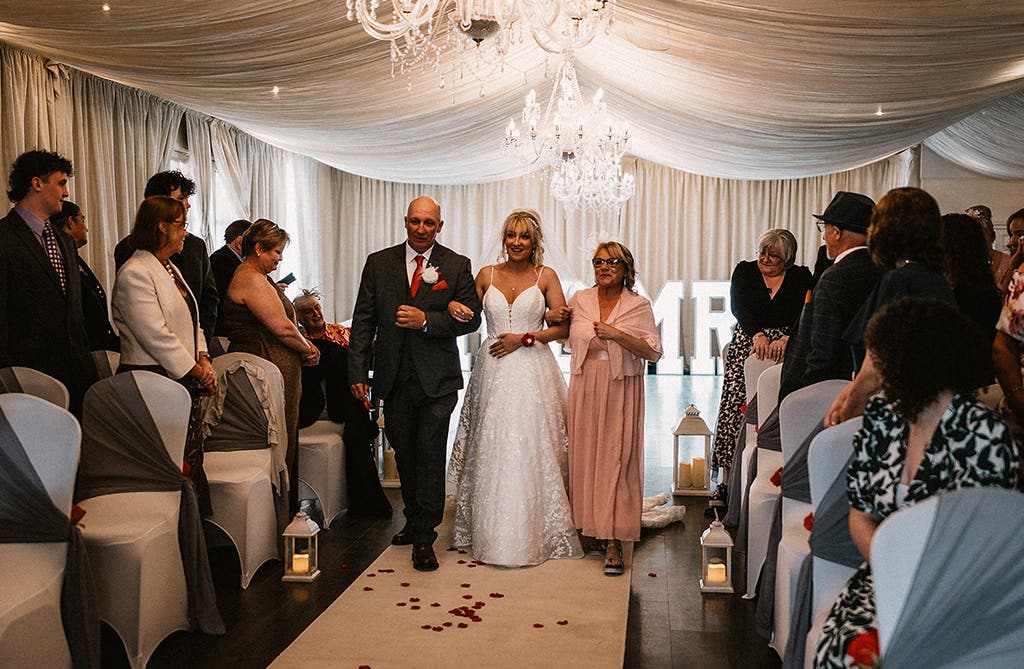 Sophie walking down the aisle with her mum and dad