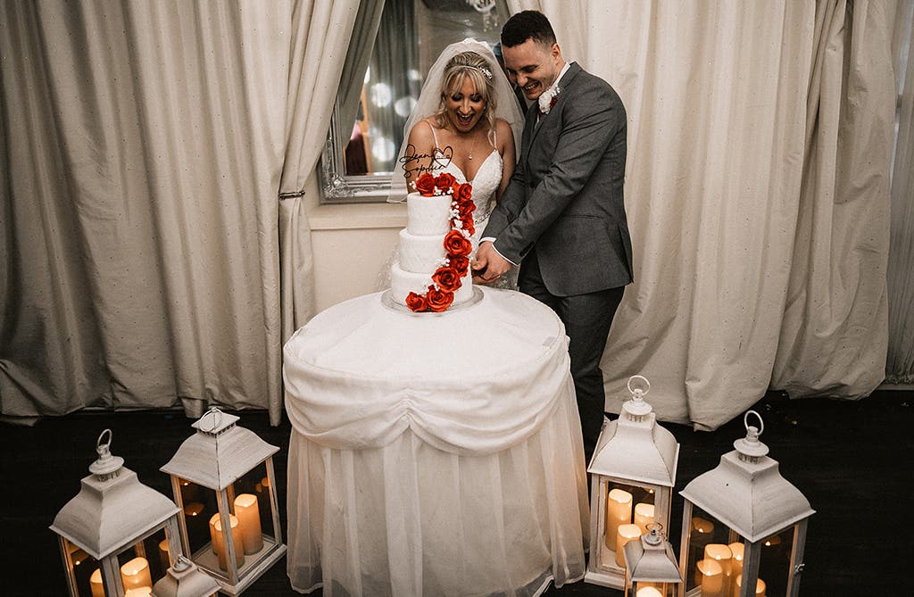 Sophie and Dean cutting their wedding cake together