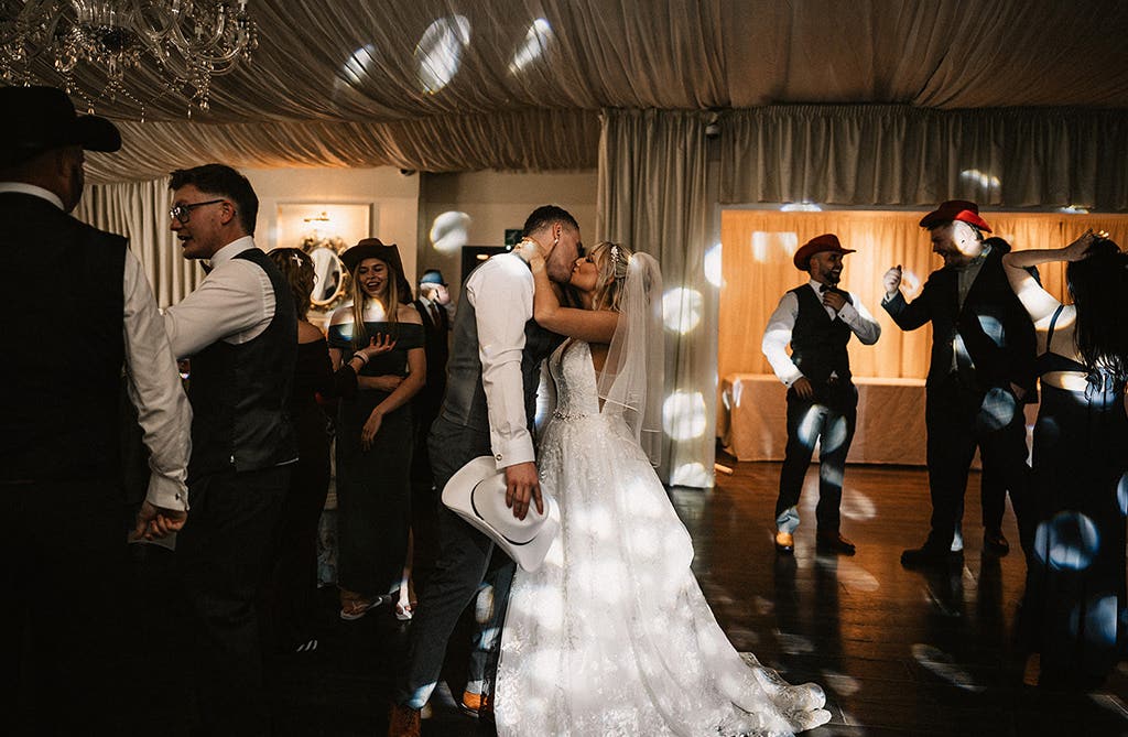 Sophie and Dean kissing on the dance floor during their wedding reception
