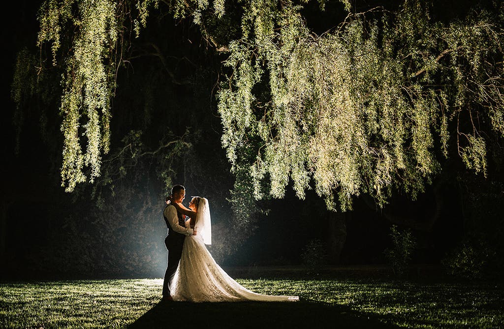 Sophie and Dean outside their wedding venue at night with dramatic lighting