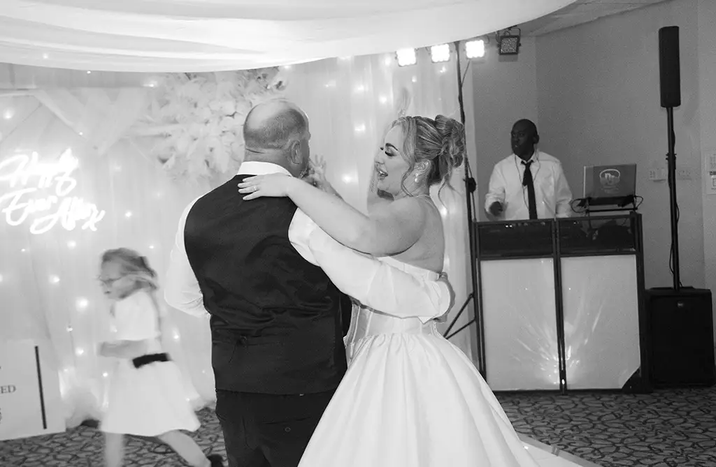 Black and white image of Rachel and Andrew dancing with their wedding guests