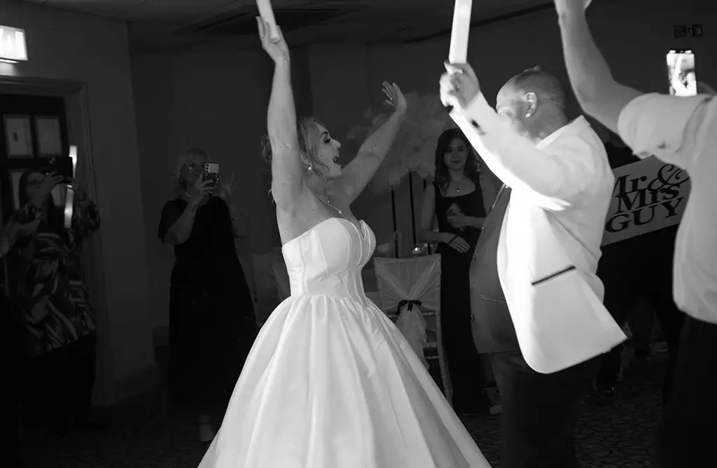 Black and white image of Rachel and Andrew dancing with their wedding guests