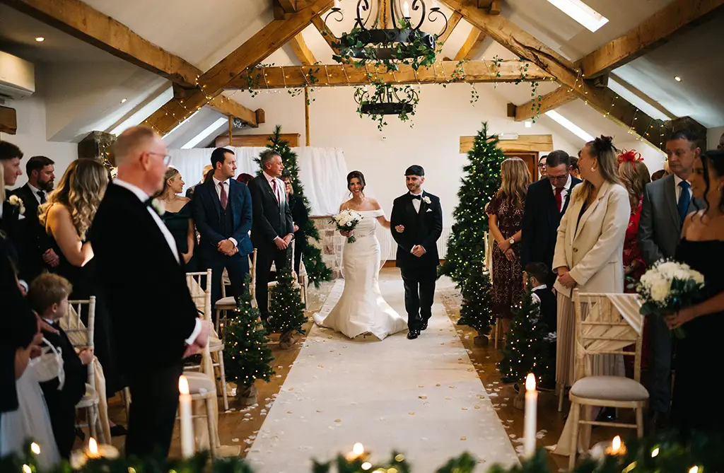 Bride walking into her winter ceremony at Beeston Manor