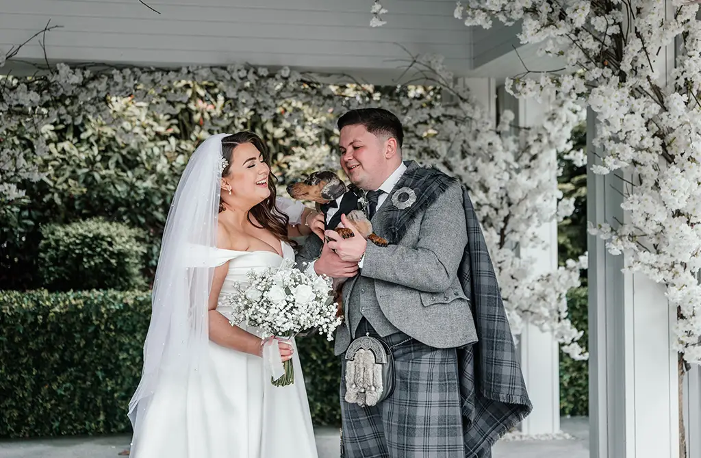 Joanna and Joseph laughing and smiling with their pet dog