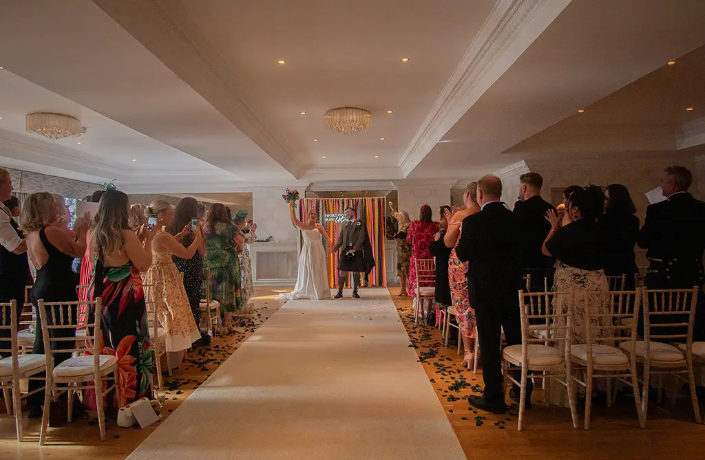Daisey and Kieran at the end of their wedding ceremony before walking back up the aisle