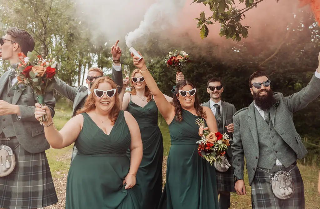 Sarah-Jane and Stephen’s wedding party wearing sunglasses with a smoke canister