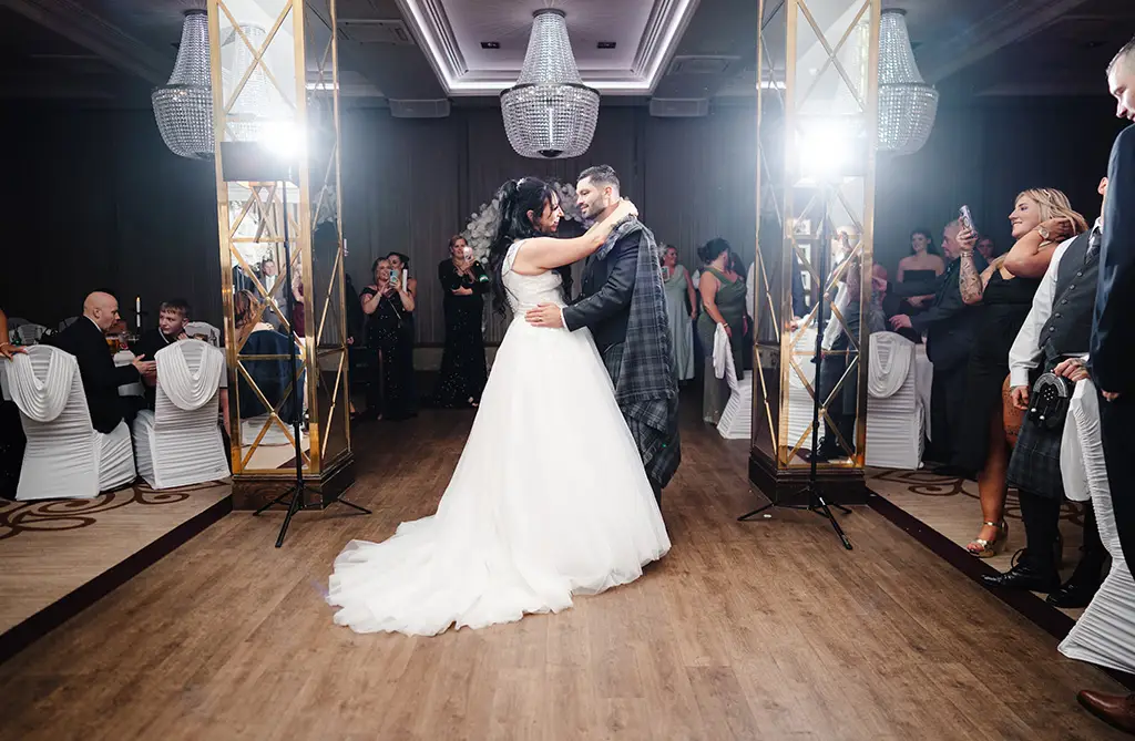 Kristeen and Ryan performing their first dance with wedding guests watching