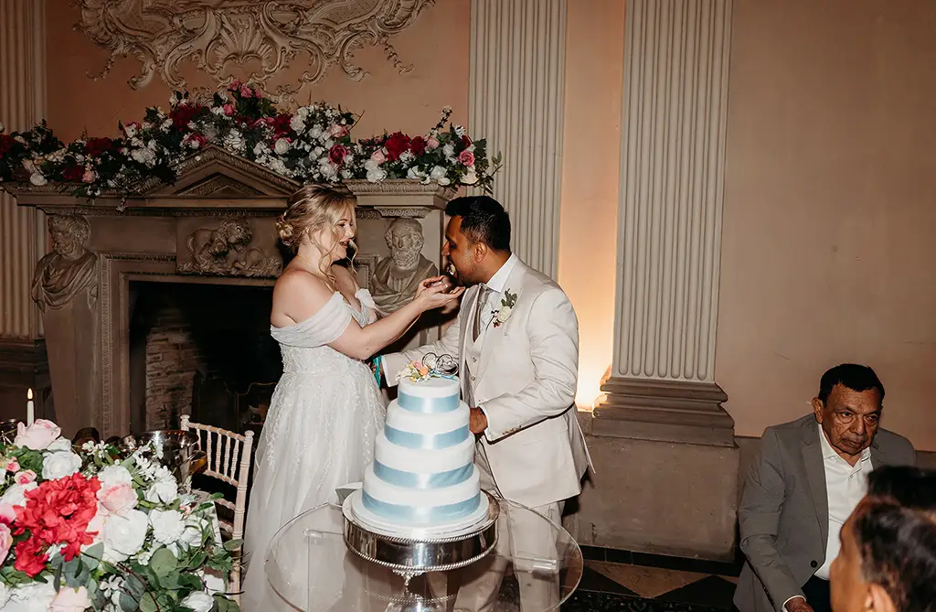Fran feeding Ronit the first slice of wedding cake during their reception