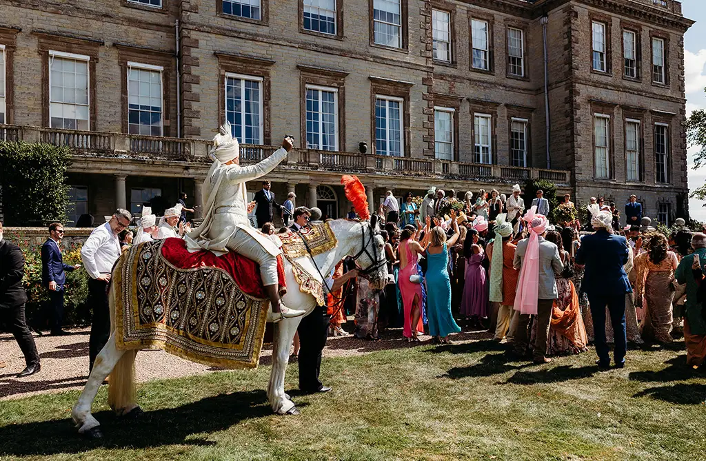 Ronit arriving on horseback during the Baraat procession at Ragley Hall wedding venue