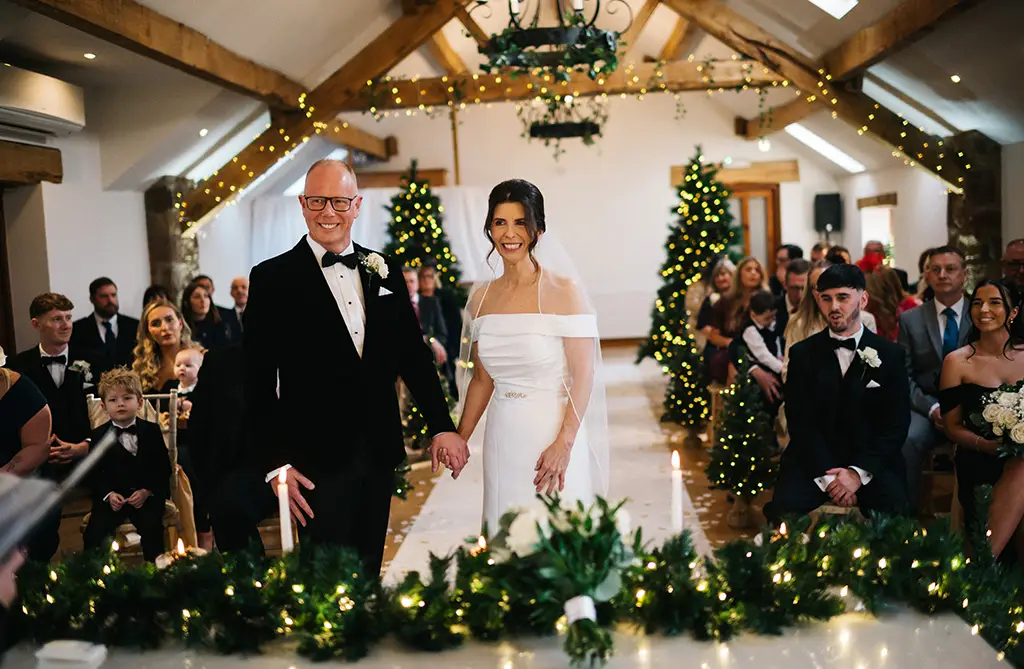Jennifer and Craig holding hands during their romantic wedding ceremony