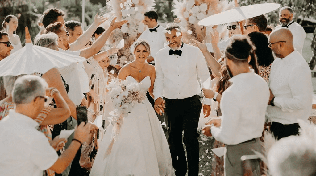 Siobhan and Brian walking hand in hand past guests throwing confetti on their wedding day