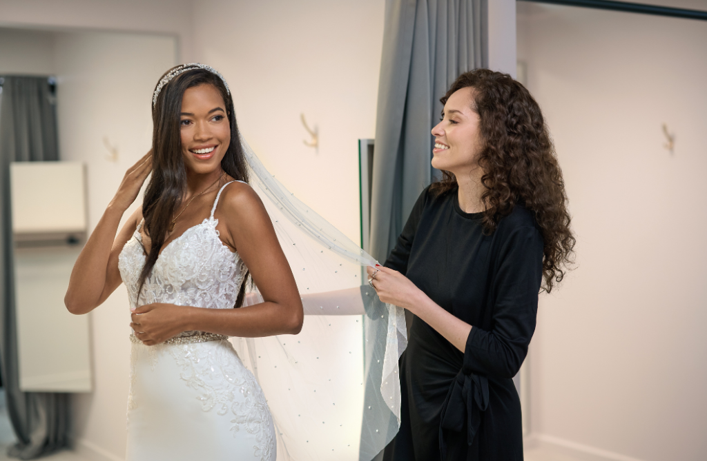 Bride looking at herself in the mirror while trying on wedding dresses